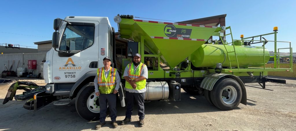 Two City of Amarillo street workers, Paul Lundegreen and Emilio Aguilera, standing in front of a specialized DuraPatcher truck.