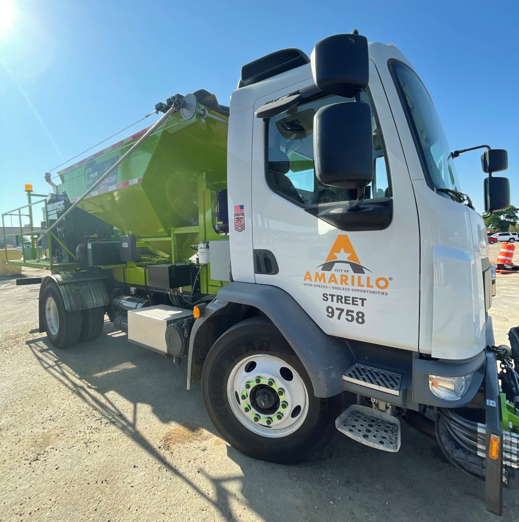 City of Amarillo Street Department vehicle with the unit number 9758, equipped with a lime green DuraPatcher used for road maintenance, parked under clear blue skies.