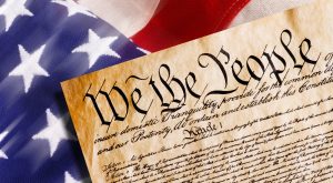 The flag of the United States of America with the top of the Declaration of Independence on top of it