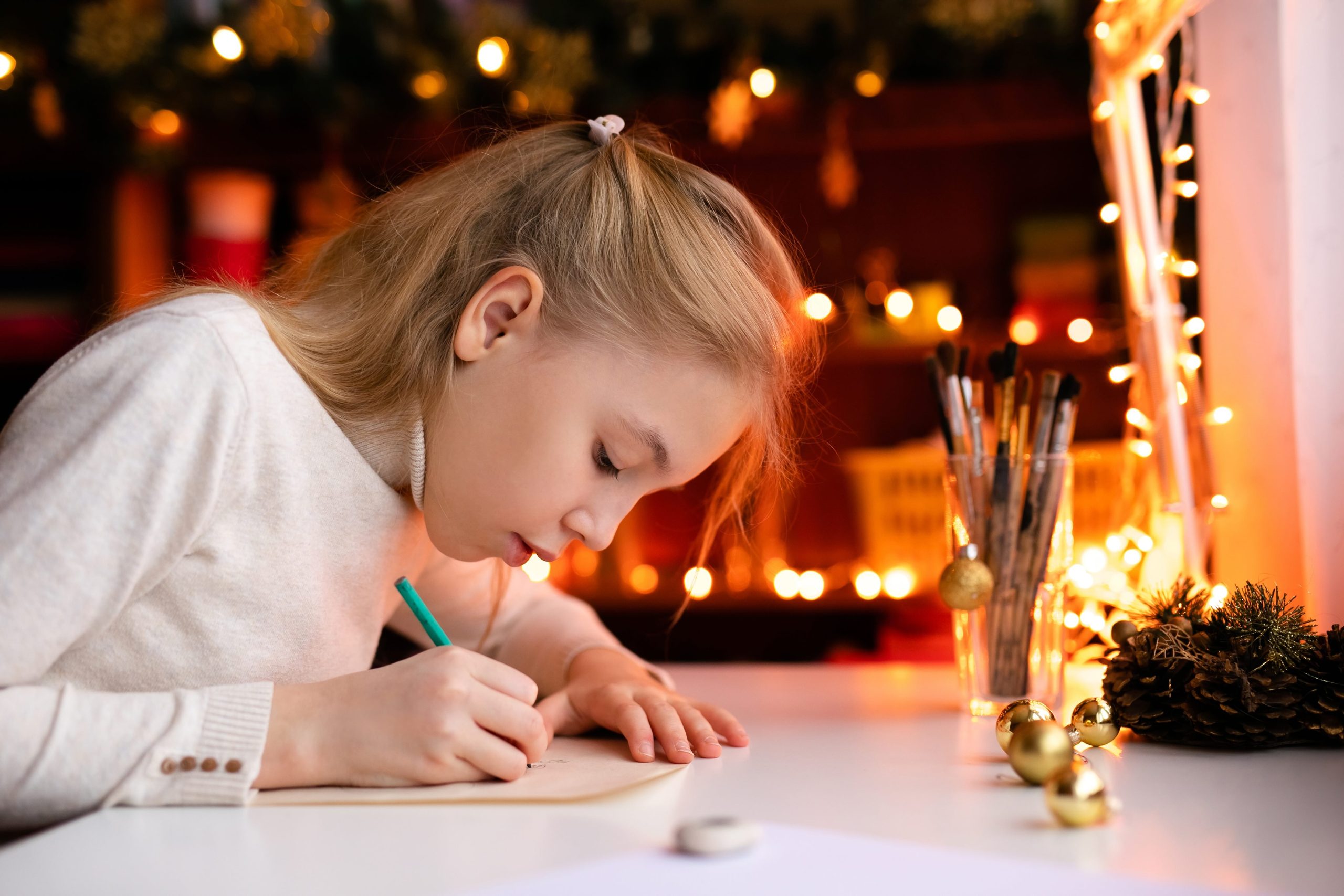 A young tween writing a letter at a desk