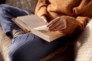 A person sitting on a couch reading a book