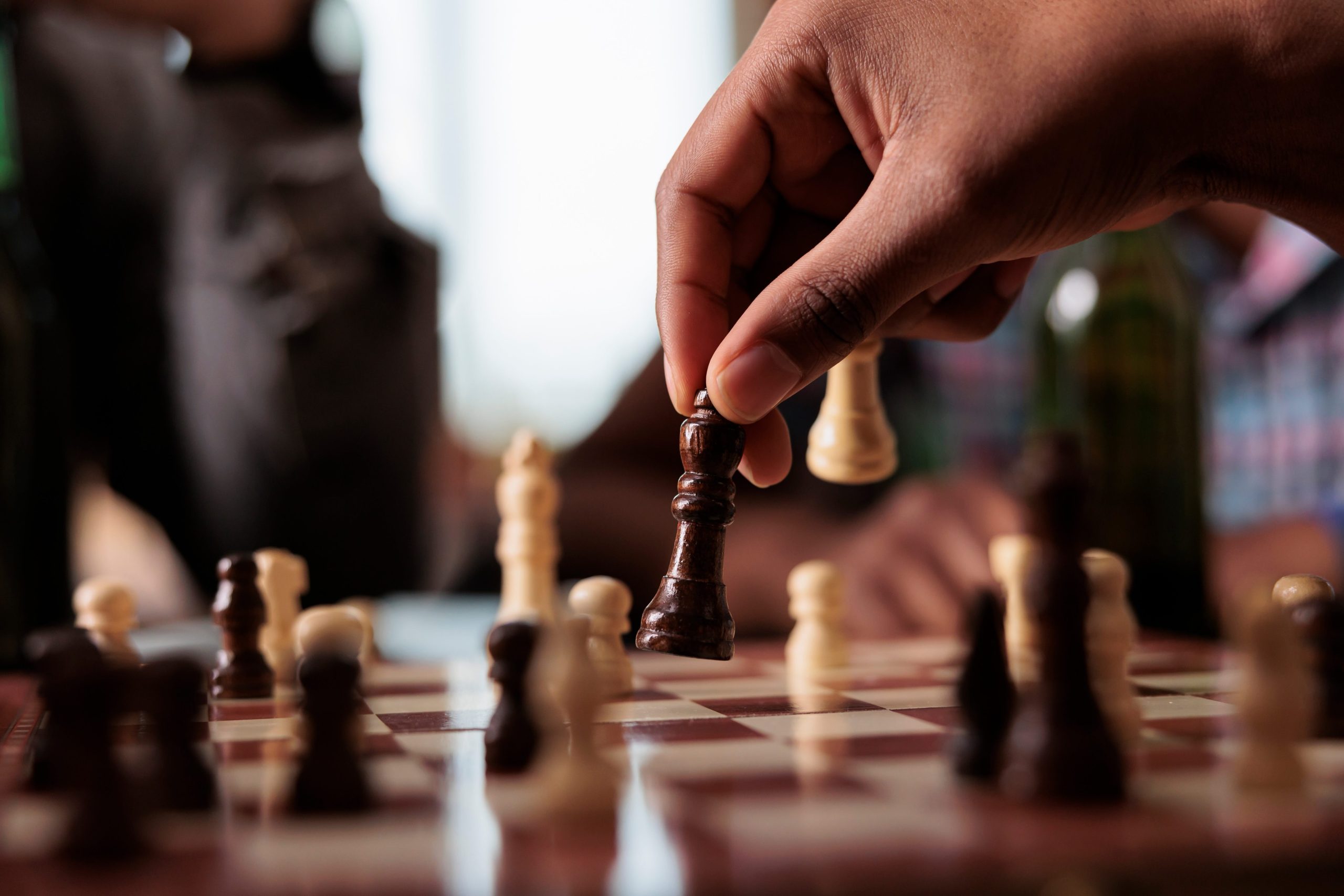 A hand moving chess piece during a game