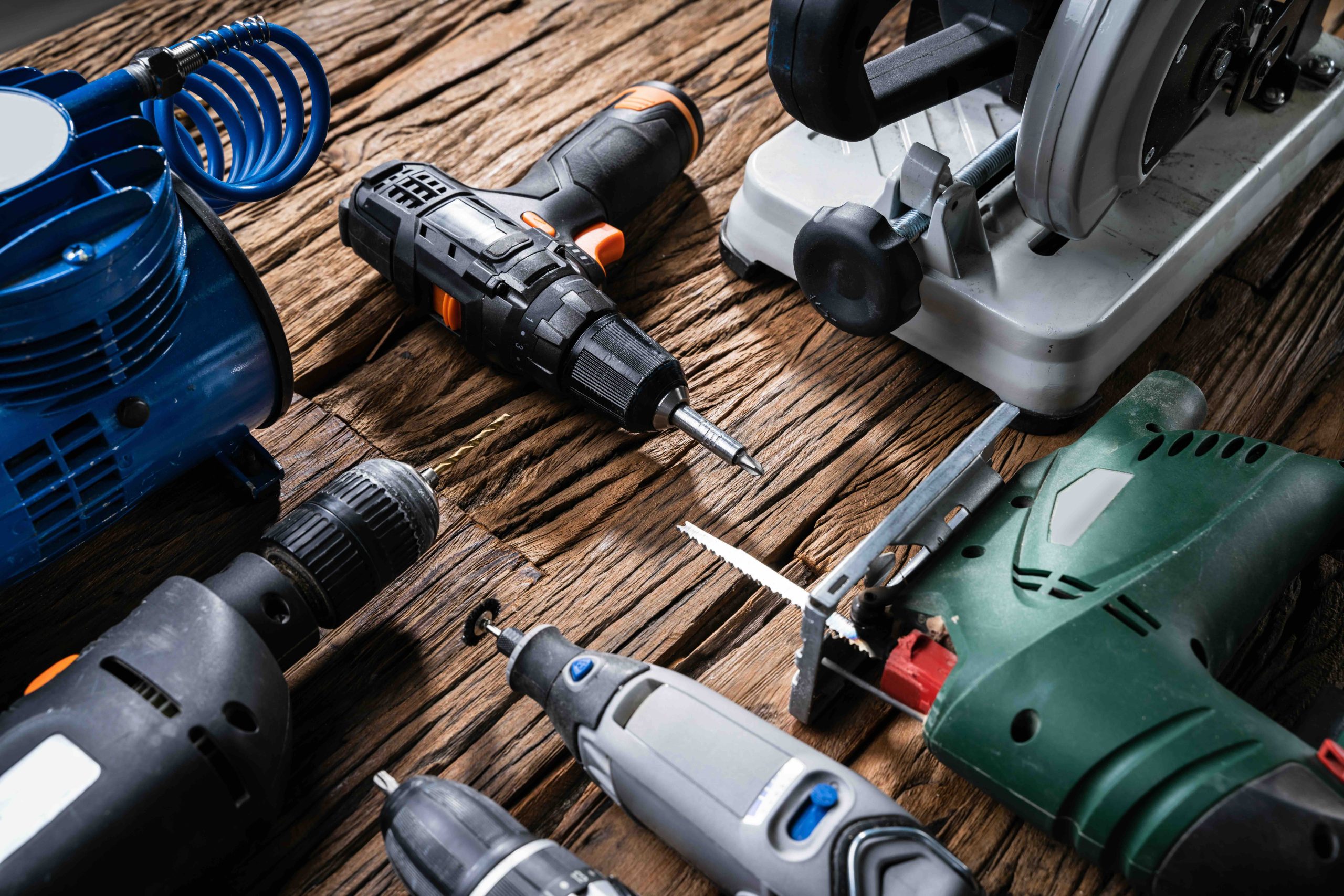 A collage of hand tools including a drill and jigsaw