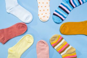 A circle of colorful socks on top of a light blue background