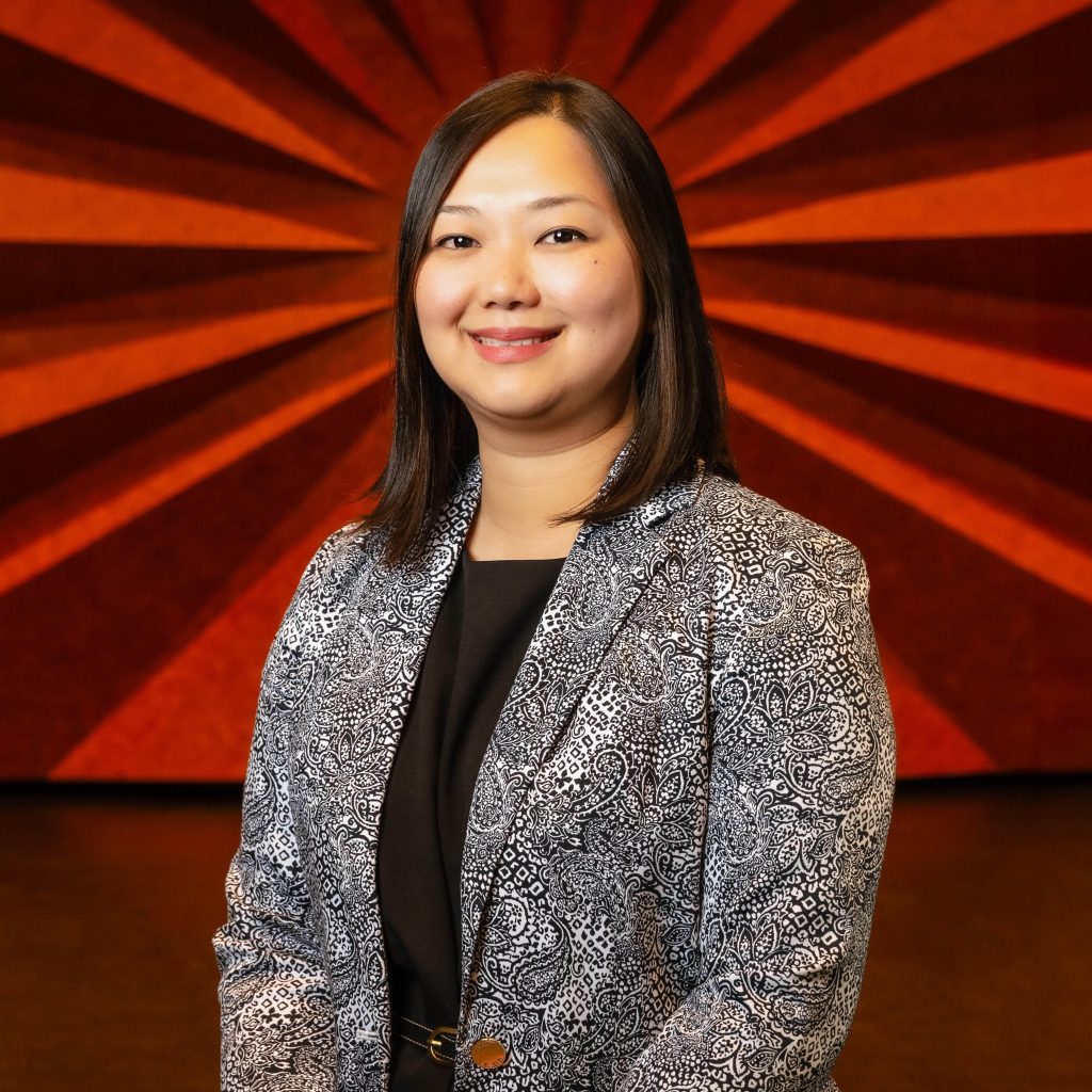 Headshot of Civic Center's Box Office Manager Han Owens wearing a black and white paisley blazer and black shirt
