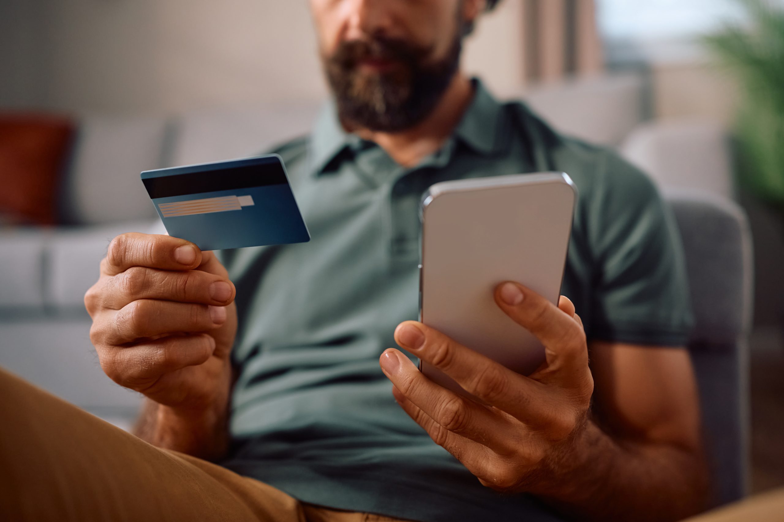 A person on the phone holding their credit card