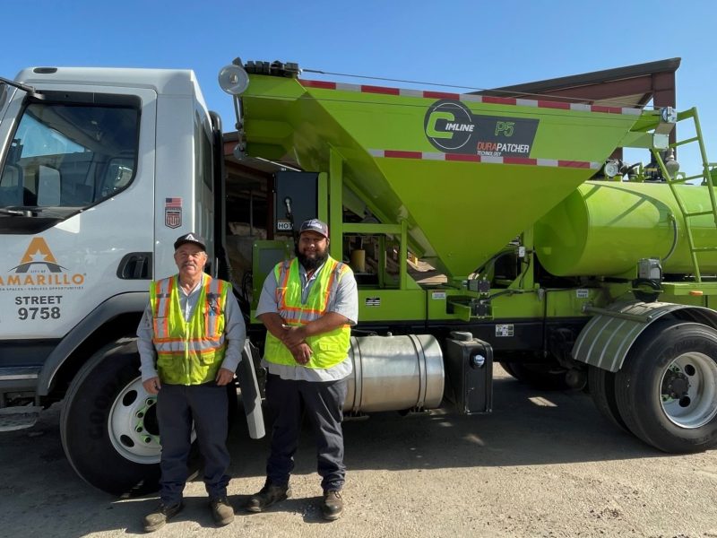 Street Department employees Paul Lundegreen and Emilio Aguilera standing in front of a DuraPatcher truck.
