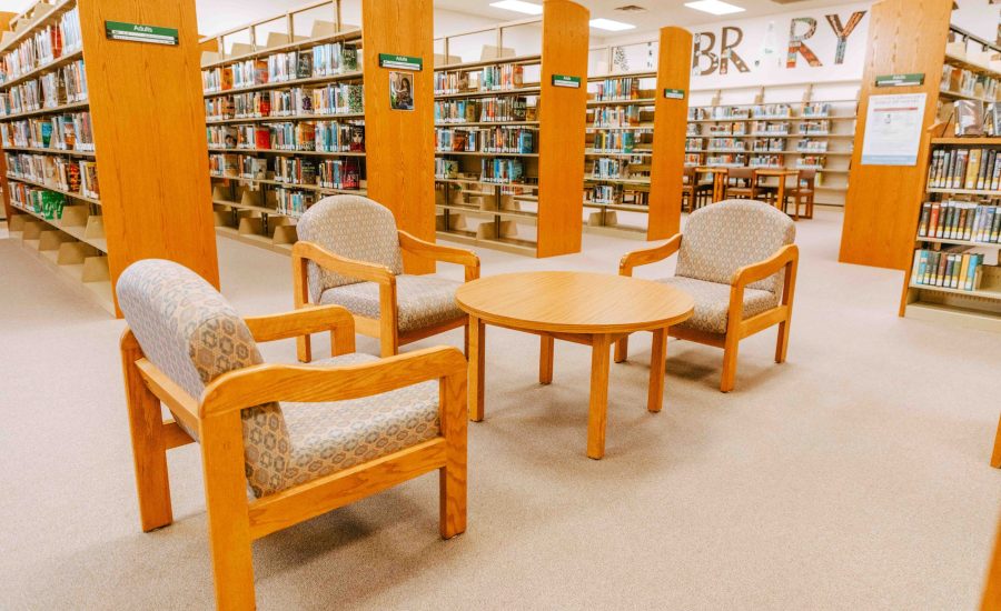 The adult section at the East Branch featuring stacks of books and a table with three chairs surrounding it