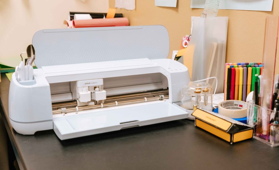 Cricut Maker next to various crafting supplies