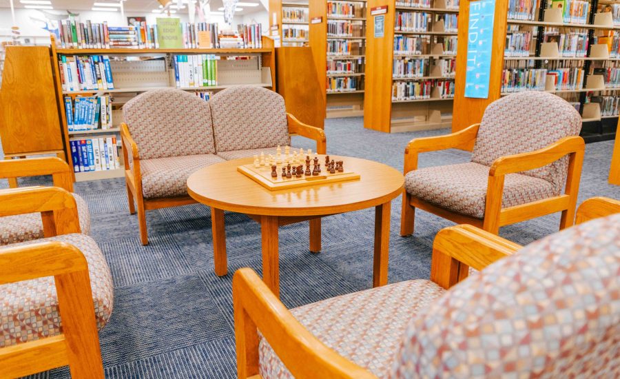 A seating area at the North Branch with a circular table with a chess board on it surrounded by chairs